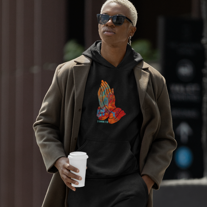 Man walking wearing a Black Pray Collection hoodie and joggers
