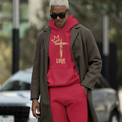 Young man with bleached blonde hair wearing the red Love Edition Hoodie and Joggers Set underneath a wool French coat. He is looking towards the ground with a serious expression.